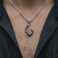 Load image into Gallery viewer, An oxidized sterling silver scorpion tail pendant is worn on the chest, displaying the curved segmented form, dark recessed detailing, pointed stinger, and bold Scorpio zodiac profile in a close-up lifestyle photograph.
