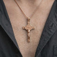 Load image into Gallery viewer, The rose gold plated Saint Benedict crucifix pendant is worn on the chest, showcasing the sculptural Jesus figure, Benedict medal center, raised cross details, and symbolic Christian jewelry style.
