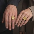 Load image into Gallery viewer, Gold plated Jesus and two thieves ring worn on the hand, highlighting the full Crucifixion scene, three crosses, INRI inscription, and detailed Calvary-inspired religious artwork.
