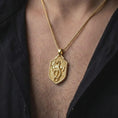 Load image into Gallery viewer, Gold plated dragon shield necklace worn on the chest, highlighting the winged dragon, coiled body, medieval crest shape, and powerful fantasy jewelry aesthetic.

