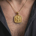 Load image into Gallery viewer, Gold plated Mexica jaguar pendant worn on the chest, highlighting the central ceremonial face, skull imagery, feline headdress, and detailed ancient-inspired geometric patterns.
