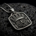 Load image into Gallery viewer, Oxidized sterling silver Tlaloc pendant on black volcanic rock, featuring iconic goggle eyes, fanged mouth, ceremonial headdress, and detailed Aztec geometric patterns.
