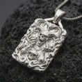 Load image into Gallery viewer, Polished sterling silver demon skull necklace displayed on dark volcanic stone, highlighting the horned skull, skeletal hands, flame details, and dramatic dark fantasy design.
