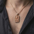 Load image into Gallery viewer, Rose gold plated horned demon pendant worn on the chest, showcasing the skull centerpiece, ram-like horns, skeletal hands, flames, and dark gothic statement design.
