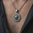 Load image into Gallery viewer, Oxidized sterling silver Viking necklace worn on the chest, displaying the horned helmet centerpiece, Norse symbols, Storm and Odin lettering, and bold round pendant profile.
