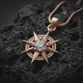 Load image into Gallery viewer, Rose gold plated Gale inspired charm displayed on textured volcanic stone, showcasing the starburst shape, round faceted centerpiece, and fantasy wizard jewelry design.
