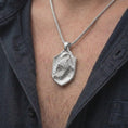 Load image into Gallery viewer, Polished silver eagle shield necklace worn on the chest, featuring sculpted feathers, powerful eagle imagery, claw details, and a bold symbolic pendant design.
