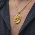 Load image into Gallery viewer, Gold plated eagle necklace worn on the chest, highlighting the detailed eagle head, layered plumage, sharp talons, and strong heraldic shield aesthetic.
