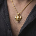 Load image into Gallery viewer, Gold plated elephant necklace worn on the chest, highlighting the detailed elephant head, prominent tusks, dimensional trunk, and powerful wildlife statement jewelry style.

