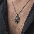 Load image into Gallery viewer, Oxidized sterling silver lion head necklace worn on the chest, showing the regal lion portrait, intricate mane texture, shield-shaped medallion, and symbolic strength-inspired jewelry design.
