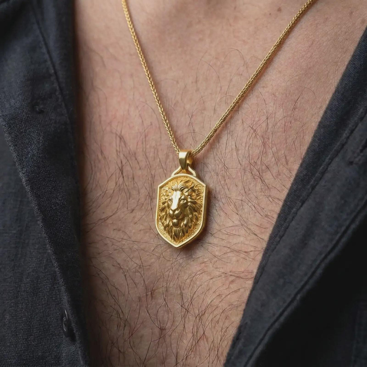 Gold plated lion shield necklace worn on the chest, highlighting the majestic lion portrait, layered fur, textured shield background, and meaningful Leo zodiac jewelry aesthetic.