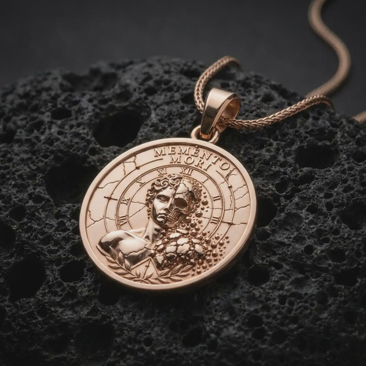 Rose gold plated Gothic Memento Mori necklace displayed on textured volcanic stone, showcasing the half-skull portrait, weathered classical bust, Roman numeral clock border, and intricate laurel branch details.