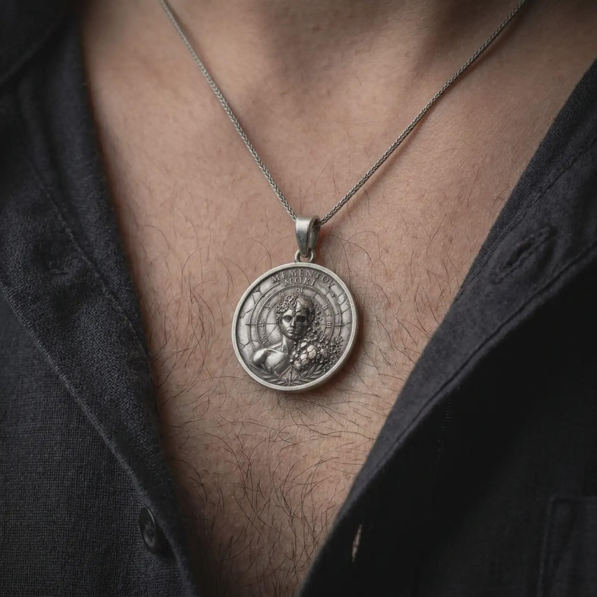 Oxidized sterling silver Memento Mori necklace worn on the chest, showing the half-human half-skeleton portrait, engraved Memento Mori inscription, Roman numeral markings, and distinctive gothic medallion design.