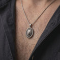 Load image into Gallery viewer, Oxidized sterling silver wolf necklace worn on the chest, showing the detailed wolf head, textured fur, pointed ears, and meaningful animal totem medallion.
