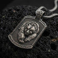 Load image into Gallery viewer, Oxidized sterling silver bear and cub pendant on black volcanic rock, featuring two sculpted bear faces, detailed fur, textured dog tag background, and decorative border.
