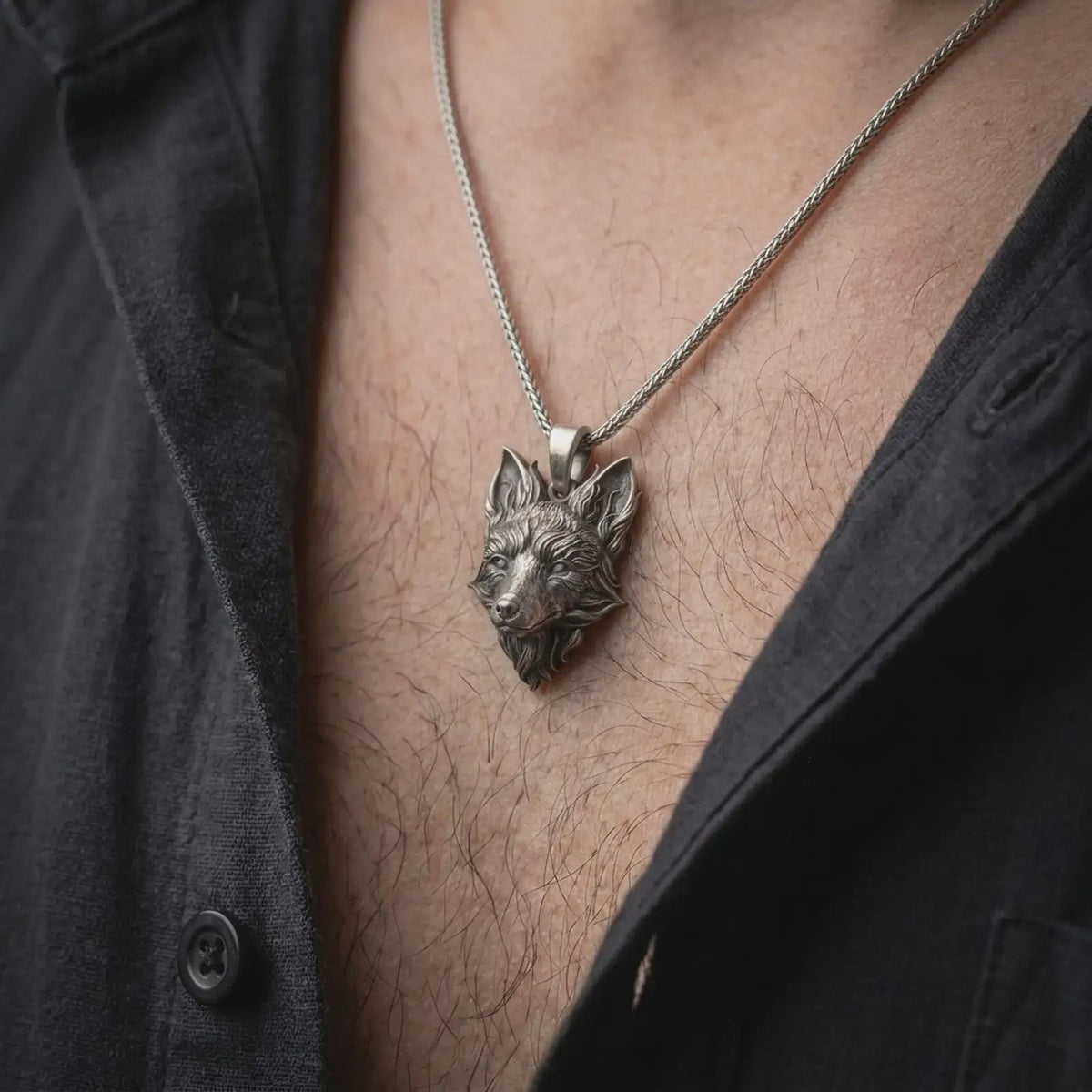 Oxidized sterling silver fox necklace worn on the chest, showing the detailed fox head, pointed ears, layered fur, and symbolic woodland animal design.