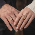 Load image into Gallery viewer, Rose gold plated dragon shield signet ring worn on the hand, showcasing the intricate winged dragon sculpture, textured heraldic shield background, coiled serpentine tail, and distinctive medieval fantasy ring design.
