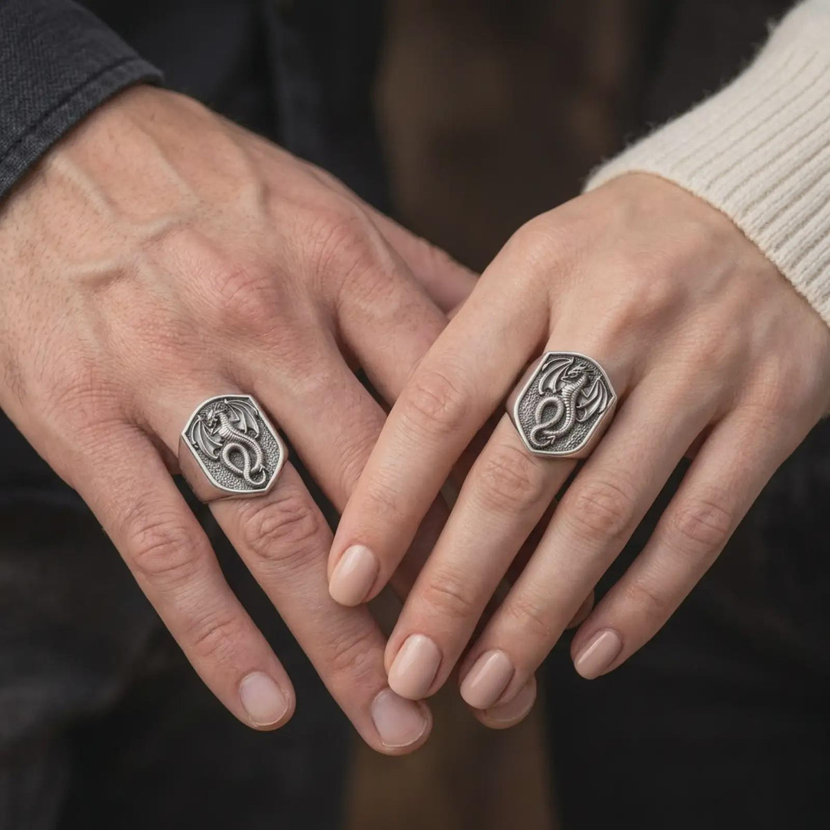 Oxidized sterling silver dragon signet ring worn on the finger, showing the winged dragon with a coiled tail, dark recessed shield background, intricate scale details, and bold gothic fantasy jewelry design.