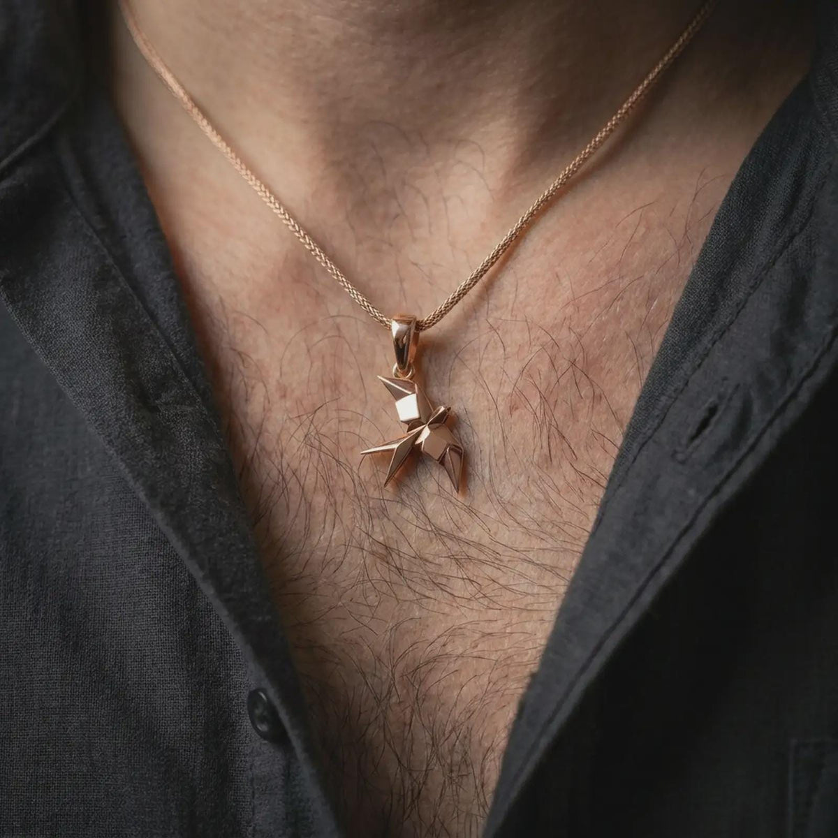 Rose gold plated origami swallow pendant worn on the chest, showcasing the geometric flying swallow silhouette, crisp folded details, and contemporary minimalist necklace style.