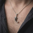 Load image into Gallery viewer, Oxidized sterling silver koi fish necklace worn on the chest, showing the detailed scales, curved swimming form, flowing fins, and symbolic Japanese carp design.
