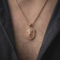 Load image into Gallery viewer, Rose gold plated lion chief pendant worn on the chest, showcasing the three-dimensional lion portrait with a feathered ceremonial-style headdress, intricate mane details, textured shield-shaped frame, and distinctive symbolic warrior jewelry aesthetic.
