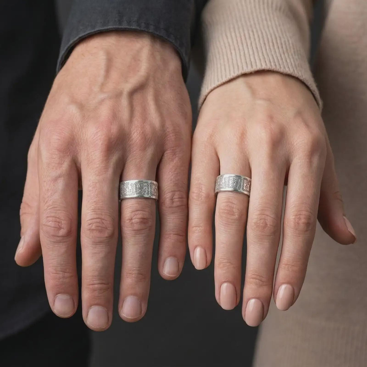 Polished 925 sterling silver matching Aztec Mayan wedding bands worn on the fingers of a man and woman together, showcasing stylized ancient figures, detailed geometric engravings, and matching bright polished silver finishes.