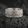 Load image into Gallery viewer, Polished 925 sterling silver Valknut ring resting on black volcanic stone, showcasing repeating triangular Norse motifs, intricate geometric metalwork, textured background, and a bright polished silver finish.
