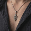 Load image into Gallery viewer, Oxidized 925 sterling silver matching dragon sword pendant necklaces worn by a man and woman together, featuring winged dragon sculptures, ornate medieval sword blades, intricate scales, decorative hilts, and coordinated dark oxidized silver finishes.
