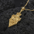 Load image into Gallery viewer, Gold plated 925 sterling silver medieval dragon dagger pendant displayed on textured black volcanic rock, featuring a raised winged dragon sculpture, coiled body, intricate sword handle, Gothic-inspired blade design, and warm gold plated finish.
