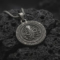 Load image into Gallery viewer, Oxidized sterling silver Cthulhu pendant on black volcanic rock, featuring a raised cephalopod sigil in the center, engraved outer ring lettering, and a dark Lovecraftian medallion design.
