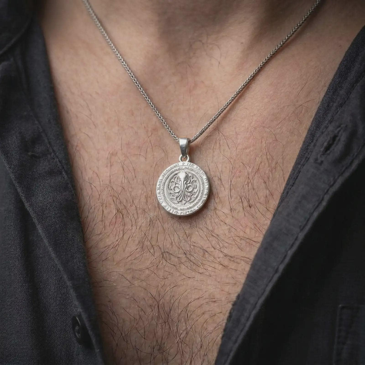 Polished silver Lovecraft necklace worn as a pendant, featuring the dimensional round medallion, detailed Cthulhu-inspired symbol, and dark fantasy jewelry look.