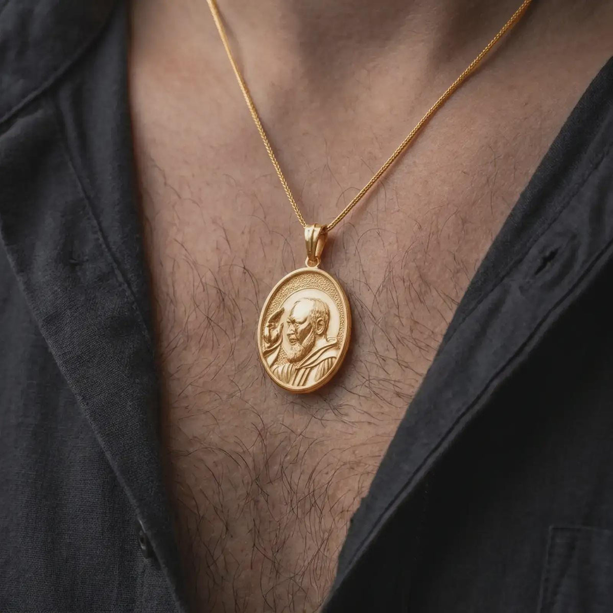 Gold plated Padre Pio medal necklace worn on the chest, highlighting the raised blessing hand, sculpted beard, saintly halo, and meaningful Christian devotional pendant styling.