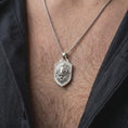 Load image into Gallery viewer, Polished silver regal lion pendant worn on the chest, featuring a detailed lion face, flowing sculpted mane, and distinctive heraldic shield necklace design for men.
