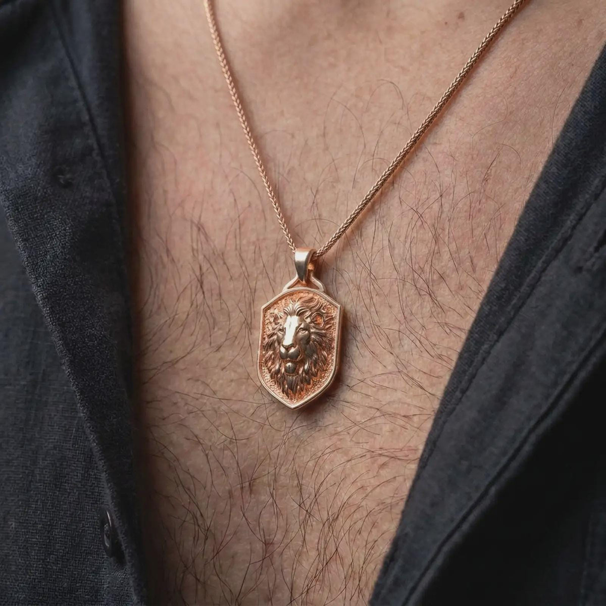 Rose gold plated lion head pendant worn on the chest, showcasing the calm lion expression, detailed flowing mane, raised shield border, and distinctive symbolic animal necklace design.