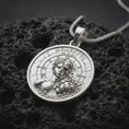 Load image into Gallery viewer, Polished sterling silver Memento Mori necklace displayed on dark volcanic stone, highlighting the classical split-face sculpture, exposed skull relief, Roman numeral dial, and detailed circular medallion.
