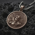 Load image into Gallery viewer, Bronze Memento Mori pendant on black volcanic rock, featuring a half-human half-skull portrait, Roman numeral clock markings, cracked stone details, and engraved Memento Mori lettering.
