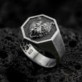Load image into Gallery viewer, Oxidized 925 sterling silver roaring bear signet ring displayed on textured black volcanic rock, featuring an open-mouthed bear head, sharp fangs, detailed fur, hexagonal frame, and dark oxidized silver finish.
