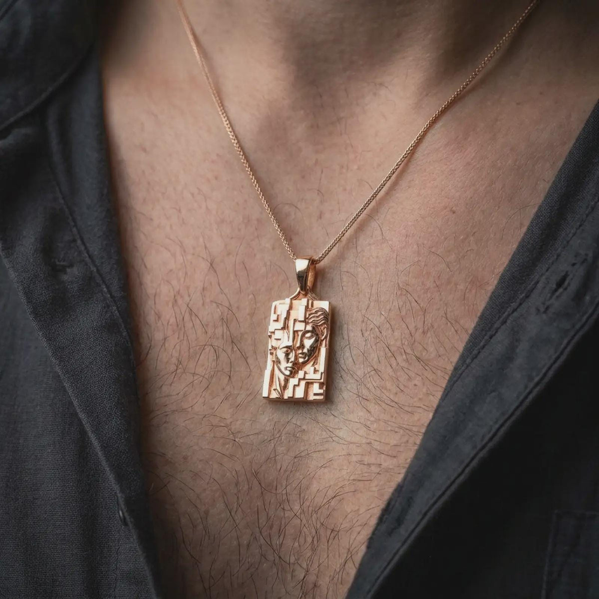 Rose gold plated Gemini twins pendant worn on the chest, showcasing the sculpted dual face composition, angular geometric detailing, and elegant Gemini astrology jewelry aesthetic.