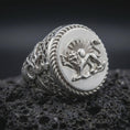Load image into Gallery viewer, Polished sterling silver Persian Lion and Sun ring displayed on dark volcanic stone, highlighting the sculpted lion relief, sunburst rays, antique coin-style face, and intricate decorative band details.
