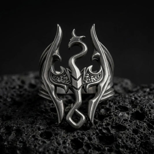 Oxidized sterling silver Skyrim Dragonborn ring on black volcanic rock, featuring the iconic dragon emblem with sweeping wings, an elongated serpentine neck, and an openwork fantasy design.