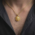 Load image into Gallery viewer, Gold plated female lion pendant worn around the neck, highlighting the sculpted lioness face, refined animal details, shield-style outline, and symbolic big cat jewelry aesthetic.

