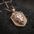 Load image into Gallery viewer, Rose gold plated lioness pendant displayed on black volcanic stone, showcasing the sculpted lioness face, elegant wild cat features, textured recessed background, and substantial pendant bail.
