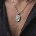Load image into Gallery viewer, Polished silver equestrian horse necklace worn on the chest, featuring the dimensional horse head sculpture, detailed facial anatomy, ornamental riding tack, flowing mane, and substantial silver pendant bail.
