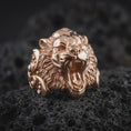 Load image into Gallery viewer, Rose gold plated tiger head statement ring displayed on black textured stone, featuring sculpted fangs, roaring mouth, detailed facial contours, and strong ornamental shoulders.
