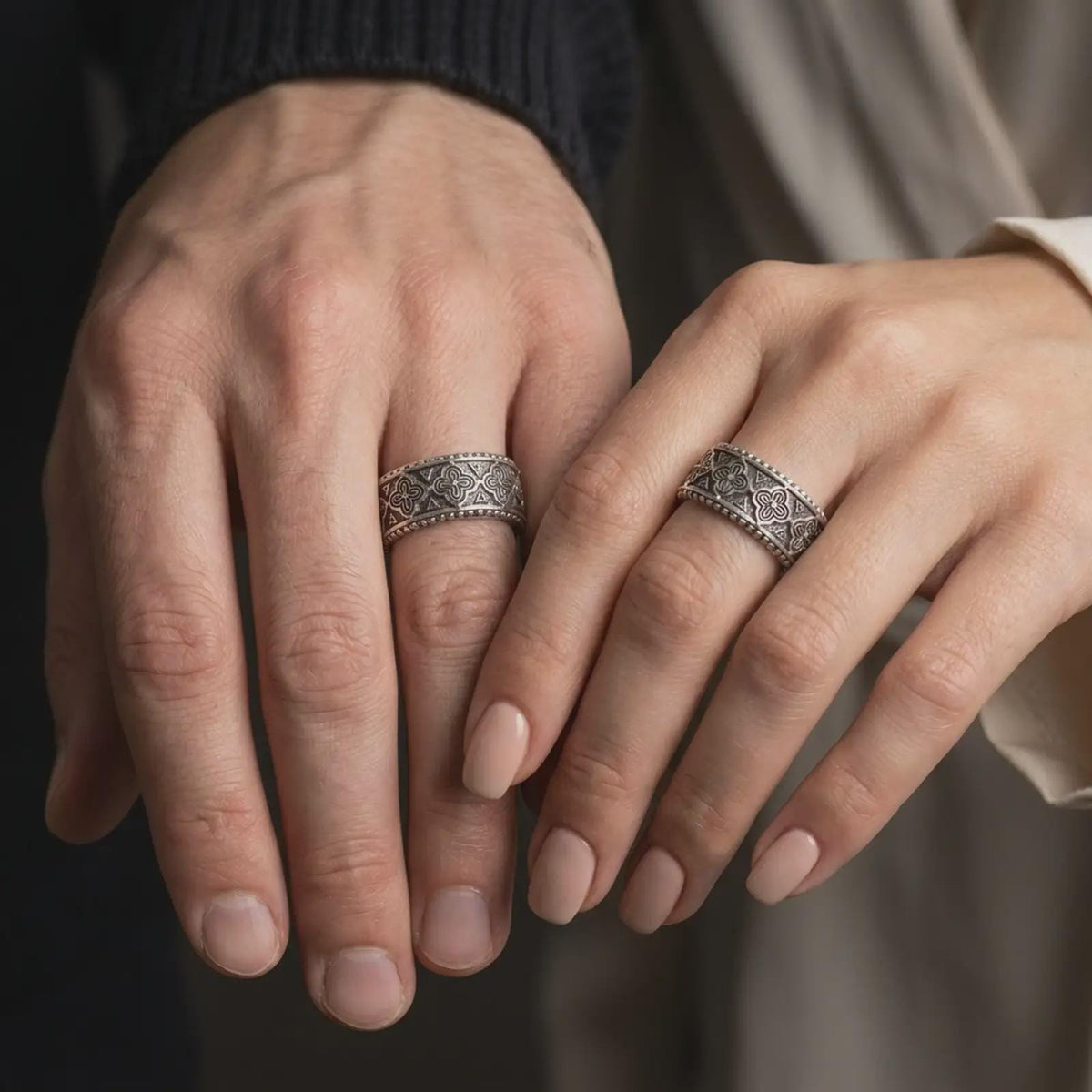 Oxidized 925 sterling silver matching Valknut Viking rings worn on the fingers of a man and woman together, featuring raised Norse triangle symbols, dark textured backgrounds, and coordinated oxidized silver finishes.