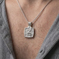 Load image into Gallery viewer, Polished Silver Saint George necklace hanging on a man's chest, highlighting the warrior saint on horseback and square religious medal.
