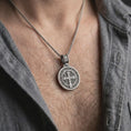 Load image into Gallery viewer, Oxidized Silver double sided Saint Benedict pendant worn on a man's chest with an open black shirt, featuring the Benedict medal side.
