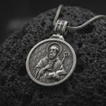 Load image into Gallery viewer, Oxidized Silver double sided Saint Benedict pendant on black volcanic rock, showing the Benedict medal cross with Latin initials and PAX inscription.
