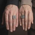 Load image into Gallery viewer, Oxidized Silver Saint Peter and Paul rings worn on the fingers of a man and woman together, showcasing the detailed apostle relief and antique finish.
