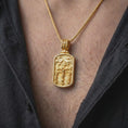 Load image into Gallery viewer, Gold Plated Golgotha Crucifixion pendant worn on a man's chest with an open black shirt, displaying the sculpted Jesus Christ and two thieves.
